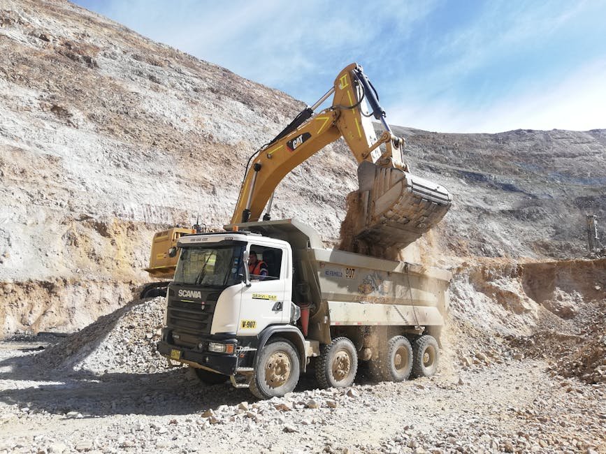 Excavator and loader preparing a dump truck while forming soil piles