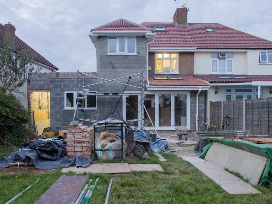 Excavator digging foundation next to an existing house for a new extension
