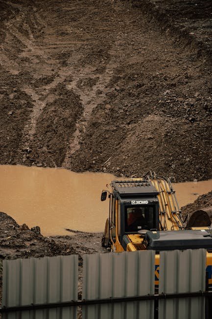 Freshly dug soil pit showing ground layers during site evaluation for a pond