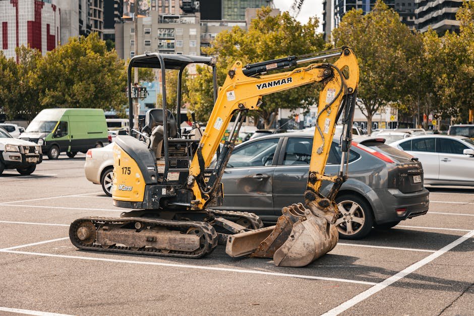 Mini excavator preparing a residential driveway base near a house
