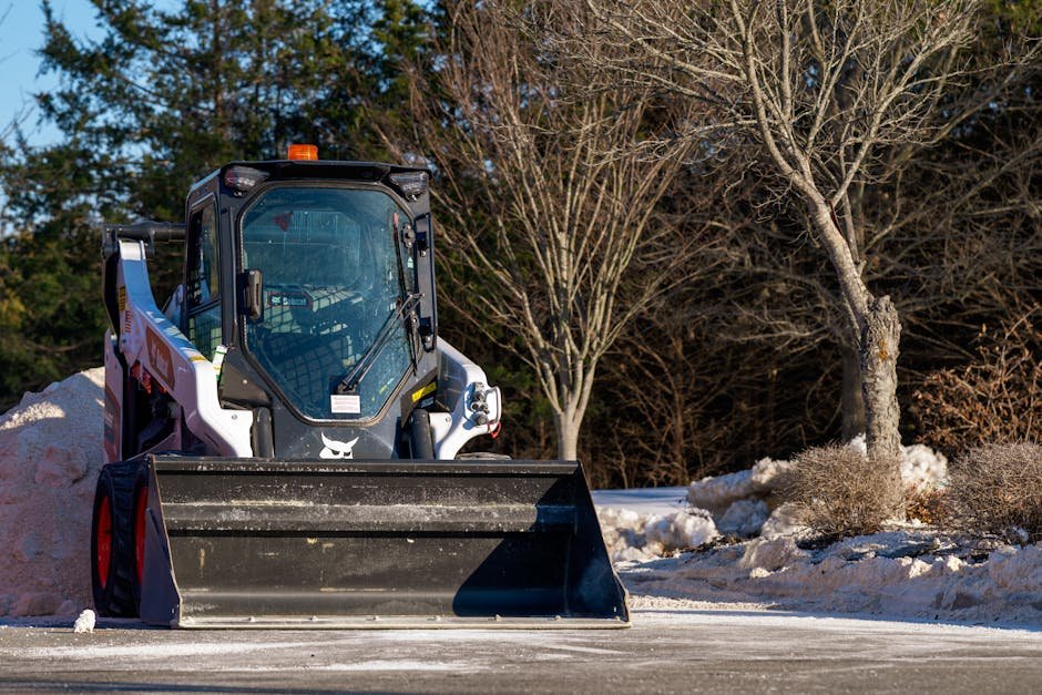 Bobcat clearing snow from a driveway or parking area in winter