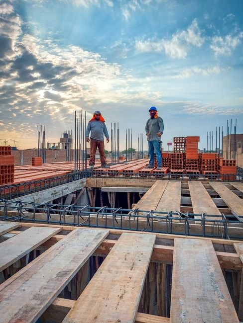 Construction workers in a site area with equipment and a clearly separated safe zone