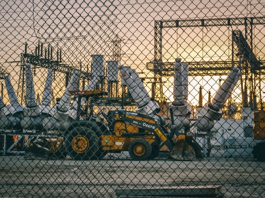 Portable generator on a construction site positioned away from workers to reduce noise